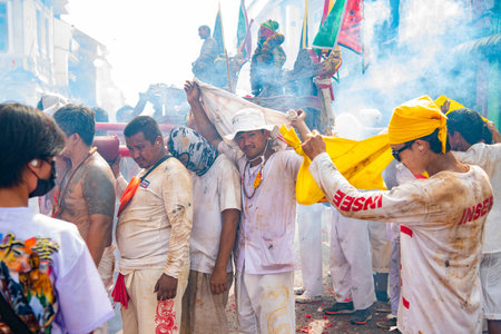 Firecrackers erupt around Devotees which carry a litter housing a Taoist god idol during a spirit...
