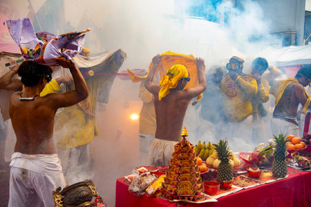 Firecrackers erupt around Devotees which carry a litter housing a Taoist god idol during a spirit...
