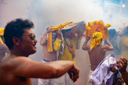 Firecrackers erupt around Devotees which carry a litter housing a Taoist god idol during a spirit...