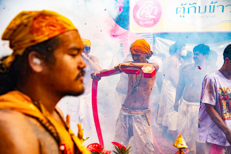 Firecrackers erupt around Devotees which carry a litter housing a Taoist god idol during a spirit Parade at Phuket City Vegetarian Festival in Thailand. Thailand, Phuket, October, 26, 2025のeditorial素材