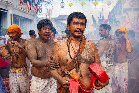 Firecrackers erupt around Devotees which carry a litter housing a Taoist god idol during a spirit...