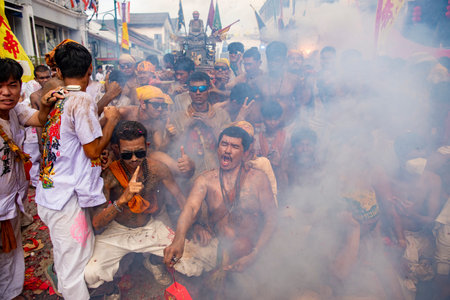 Firecrackers erupt around Devotees which carry a litter housing a Taoist god idol during a spirit Parade at Phuket City Vegetarian Festival in Thailand. Thailand, Phuket, October, 26, 2025のeditorial素材