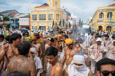 Devotees carry a litter housing a Taoist god idol during at spirit ceremony and Parade at Phuket Vegetarian Festival in Phuket City in Thailand. Thailand, Phuket, October, 26, 2025のeditorial素材
