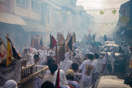 Devotees carry a litter housing a Taoist god idol during at spirit ceremony and Parade at Phuket...