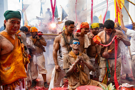 Firecrackers erupt around Devotees which carry a litter housing a Taoist god idol during a spirit...