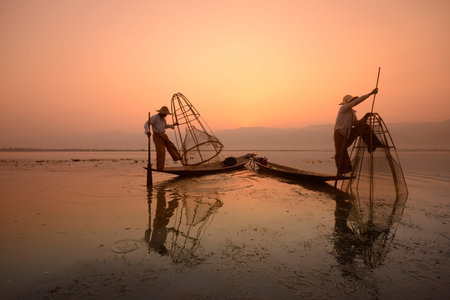 Fishermen at sunrise in the Landscape on the Inle Lake in the Shan State in the east of Myanmar in Southeastasia.のeditorial素材
