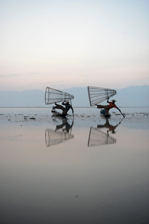 Fishermen at sunrise in the Landscape on the Inle Lake in the Shan State in the east of Myanmar in...