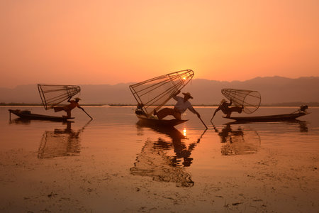 Fishermen at sunrise in the Landscape on the Inle Lake in the Shan State in the east of Myanmar in Southeastasia.のeditorial素材