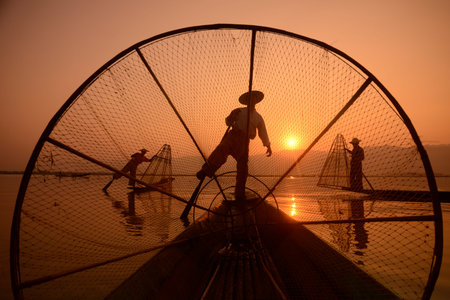 Fishermen at sunrise in the Landscape on the Inle Lake in the Shan State in the east of Myanmar in...
