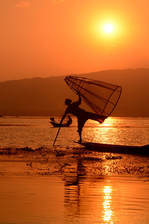 Fishermen at sunset in the Landscape on the Inle Lake in the Shan State in the east of Myanmar in Southeastasia.のeditorial素材