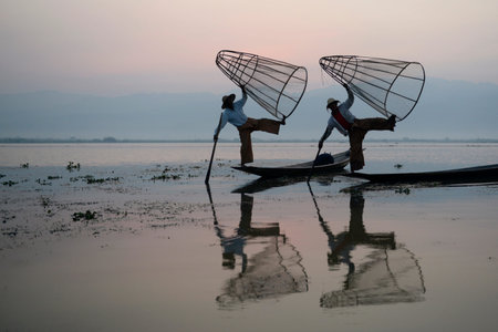 Fishermen at sunrise in the Landscape on the Inle Lake in the Shan State in the east of Myanmar in Southeastasia.のeditorial素材