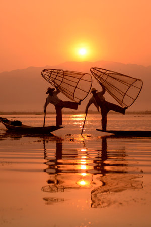 Fishermen at sunrise in the Landscape on the Inle Lake in the Shan State in the east of Myanmar in Southeastasia.のeditorial素材