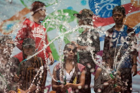 People at the Waterparty at the Thingyan Water Festival at the Myanmar New Year in the city centre of Mandalay in Manamar in Southeastasia.のeditorial素材