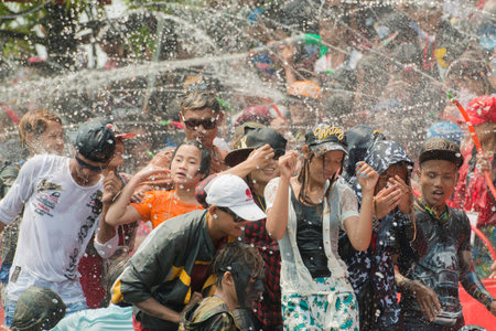People at the Waterparty at the Thingyan Water Festival at the Myanmar New Year in the city centre of Mandalay in Manamar in Southeastasia.のeditorial素材