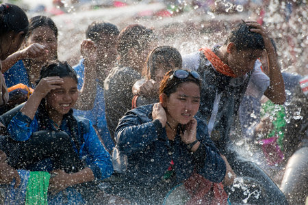 People at the Waterparty at the Thingyan Water Festival at the Myanmar New Year in the city centre of Mandalay in Manamar in Southeastasia.のeditorial素材