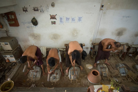 workers pound sheets of Gold leaf at a Gold pounder Factory the City of Mandalay in Myanmar in Southeastasia.のeditorial素材