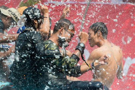 People at the Waterparty at the Thingyan Water Festival at the Myanmar New Year in the city centre of Mandalay in Manamar in Southeastasia.のeditorial素材