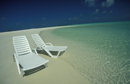 a beach with the seascape of the island and atoll of the Maldives Islands in the indian ocean.