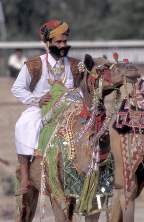 a camel herder in traditional Rajasthani dress at the Bikaner Camel Festival in the Town of Bikaner in the Province of Rajasthan in India.  India, Bikaner, January, 1998のeditorial素材