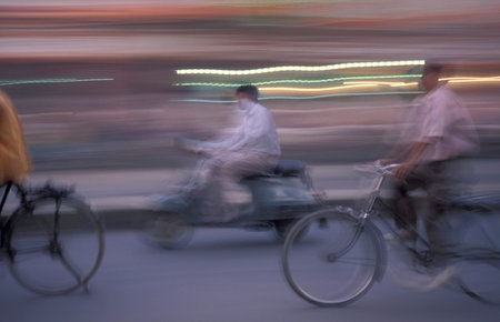 a Motorbike and bicycle traffic on a road in the City of Jaipur in the Province of Rajasthan in...