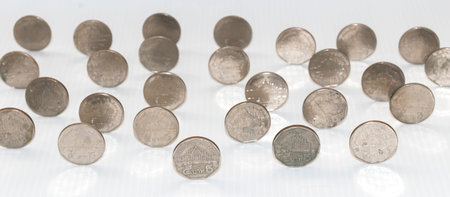 Too many coins are standing on the white background.