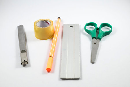Scissor, ruler, cutter, tape and color pen on the white background.