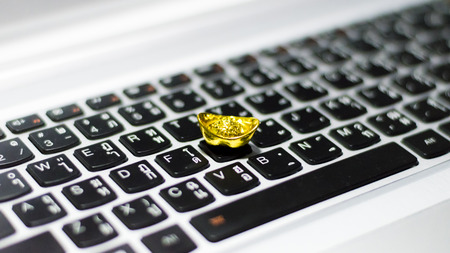 A gold bar on the computer keyboard.の写真素材