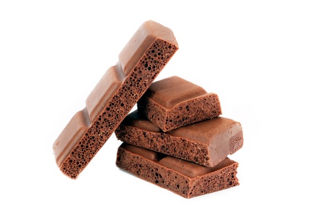 Aerated milk chocolate pieces isolated on white backgroundの写真素材