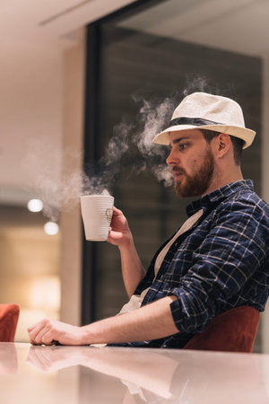 Digital nomad burning himself with a cup of tea while working. Lifestyle concept