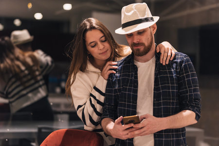 Couple of digital nomads looking at content on their phone to get ideas. Remote work conceptの写真素材