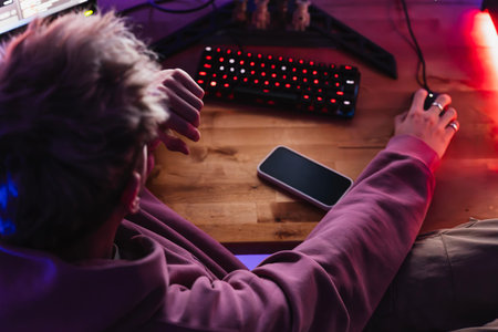 Background of an unrecognizable gamer from above playing alone in his room