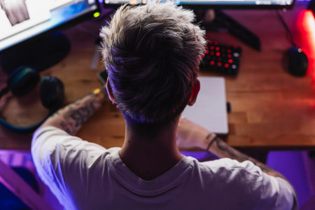 Unrecognizable teenager boy sitting at the desk in his room studying for the high school examの写真素材