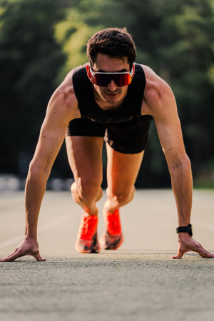 Expert athlete in starting position staring straight ahead with focused face. Vertical