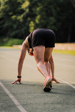 Professional athlete in starting position during a training session on the athletics track