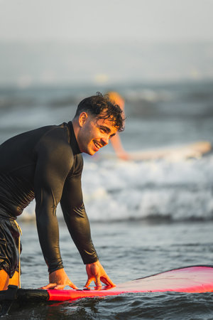 Happy young man after an afternoon surfing at the beachの写真素材