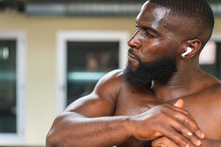 Black athlete stretching muscles in the sports centerの写真素材