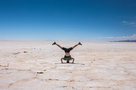 young caucasian man doing handstand in a salt flatの写真素材