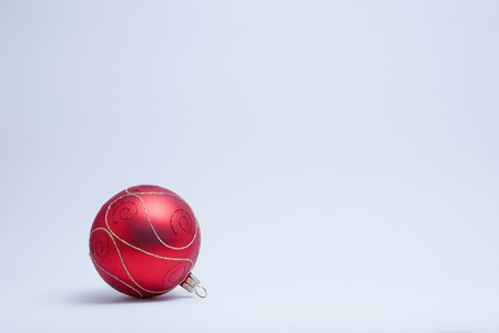 Single red and gold bauble on a white background.の写真素材