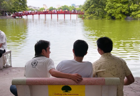Unidentified men relaxing at Hoan Kiem Lake with the Huk Bridge in the distance, Hanoi, Vietnam, July 4 2010. Meaning のeditorial素材
