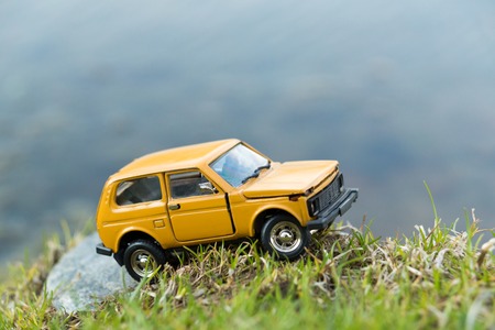 Close up image of yellow toy SUV standing on the river shoreの写真素材