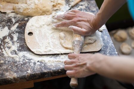 Top view of a piece of dough being rolled with a rolling pinの写真素材
