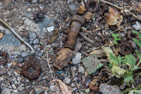 Rusty bolts and nuts lying on the ground.