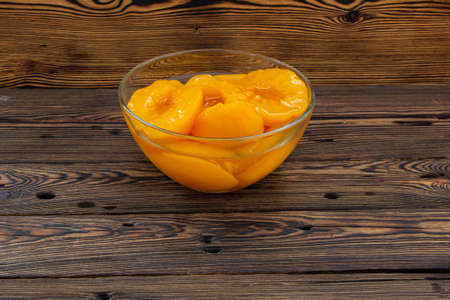 Canned peaches in a glass bowl on the table.の写真素材