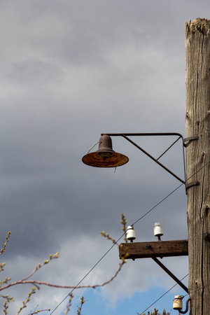 Vintage street lamp on a wooden pole against the sky.の写真素材
