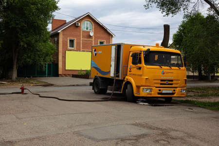 Orenburg, Orenburg region, Russia - 06.13.2021: The car of the Rosvodokanal service connected to the hydrant with a hose. Inscriptions on the car "Rosvodokanal Orenburg", "We take care of water"のeditorial素材