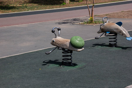 Wooden swing on the playground made in the form of a dolphin and a snail.の写真素材