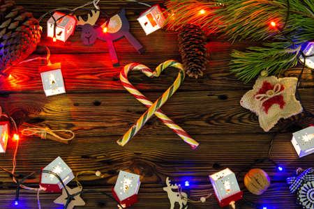 Christmas tree toys and sweets on a wooden background among pine branches.の写真素材