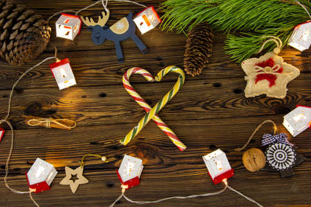 Christmas tree toys and sweets on a wooden background among pine branches.の写真素材