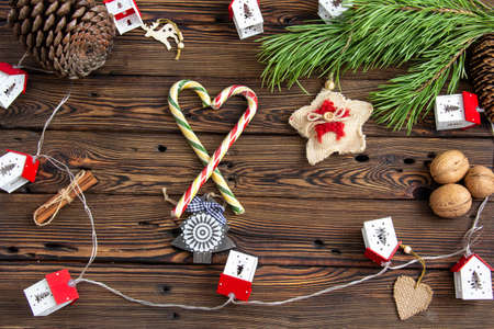Christmas tree toys and sweets on a wooden background among pine branches.の写真素材