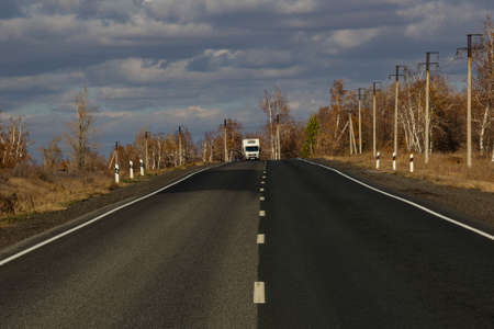 Orenburg, Russia - 10.10.2021: A truck is moving along the highway among the trees.のeditorial素材